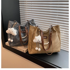 Detail of minimalist tote bags featuring pearl chains, leather straps and cloud charms