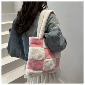 Detail of pink and white plush checkerboard tote bag showing soft texture and shoulder fit
