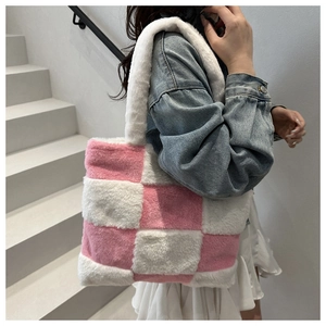 Model showing a soft plush pink and white checkerboard tote bag on a shoulder