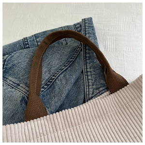 Detail of cream corduroy tote bag with brown straps showing inner storage capacity