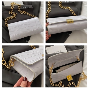 Gros plan du sac à main blanc motif croco avec chaîne dorée et fermoir métallique