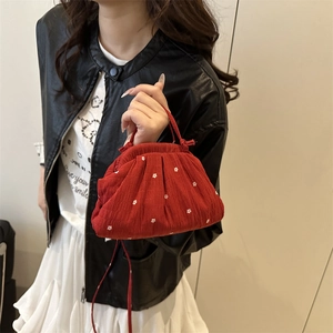 Sac à main plissé rouge avec fleurs blanches pour un look mode printanier tendance
