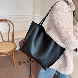 Large black vintage tote bag styled with casual outfit for daily commuting look