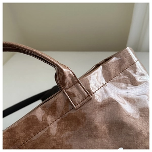Close-up of durable brown DuPont paper tote with reinforced stitching and waterproof coating