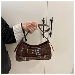 Detail of dark brown leather underarm bag with punk silver buckles and rivets