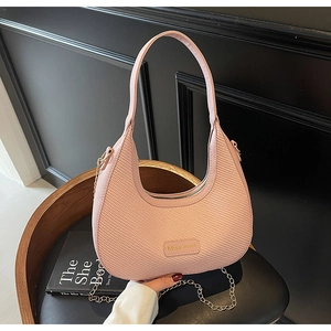 Detailed view of pink hobo bag with woven texture, gold chain and Miss mini logo plate