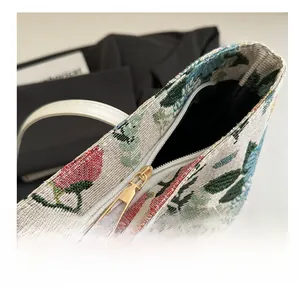 Detailed close-up of a smooth gold metal zipper on a floral pattern fabric tote bag