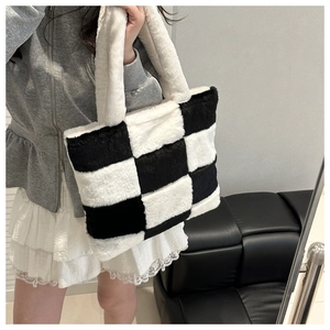 Detailed close-up of a large black and white checkerboard faux fur tote bag
