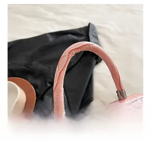 Close-up of pink crocodile pattern leather bag featuring sturdy handle and silver metal hardware