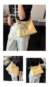 Détail du sac cabas en PU crème avec un nœud en dentelle délicat et pendentif perle