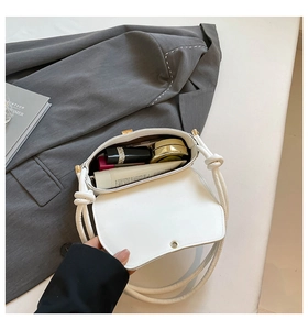 Detail view showing white baguette bag interior with magnetic flap and knot strap