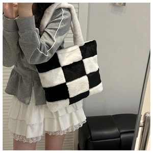 Detail of checkered plush tote bag texture and soft shoulder strap on female model