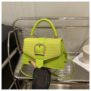 Détail du sac à main vert fluo montrant le rabat tissé et la boucle dorée carrée