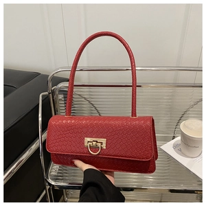 Close-up of red woven shoulder bag with golden metallic clasp and elegant texture