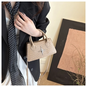 Detail of khaki textured mini handbag featuring a silver star metal charm and woven pattern