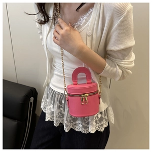 Detailaufnahme der rosa Mini-Eimertasche mit goldener Kette und glatter Lederstruktur