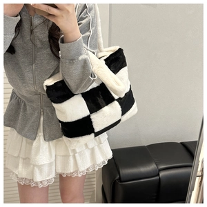 Mirror selfie showing a large black and white checkered plush tote bag for winter