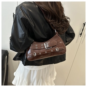 Detail view of a dark brown half-moon underarm bag with silver buckles and rivets