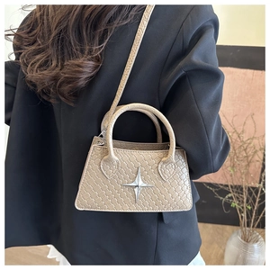 Detail of beige woven texture handbag with star-shaped silver buckle on dark suit background