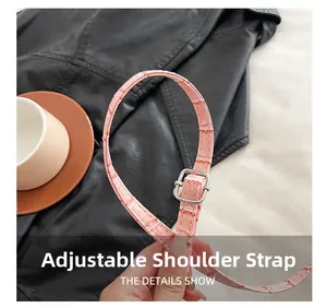 Detailed close-up of pink croc-embossed adjustable shoulder strap with silver buckle