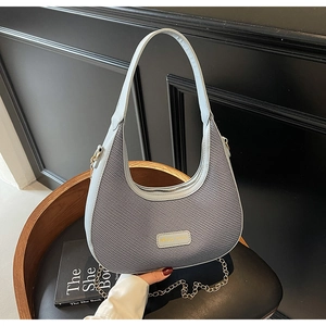 Detail of light blue hobo bag showing woven fabric texture and Mise mini metal logo