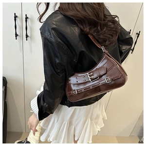 Brown vintage faux leather underarm bag with silver buckle details worn by model