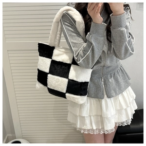 Close-up of fluffy black and white checkerboard plush tote bag with soft faux fur texture