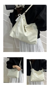 Détail du sac à bandoulière en cuir crème avec nœud en dentelle et pendentif en perle