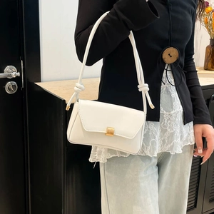 Minimalist white leather baguette bag with golden square clasp and knotted cord strap