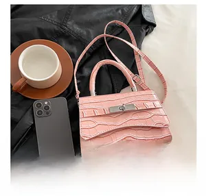 Detailed view of pink croc-effect faux leather texture and silver twist-lock closure