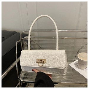 Close-up of white woven texture shoulder bag with gold metal buckle held in a chic setting