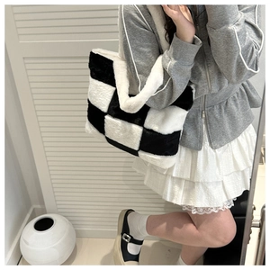 Detail of soft black and white checkerboard faux fur tote bag with plush handle