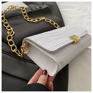 Vue détaillée du sac à rabat blanc motif crocodile avec grosse chaîne dorée