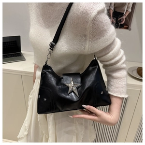 Detail of black leather shoulder bag featuring silver star stud and metallic star buckle