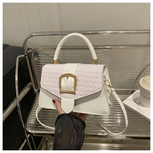 Détail du sac blanc avec rabat tissé et boucle en métal en forme de fer à cheval