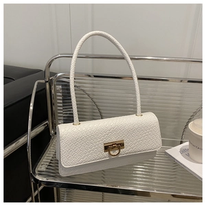 Detail of white woven texture underarm bag featuring a golden circular metal lock