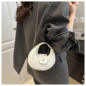 Detailed view of a white crescent shoulder bag featuring a gold chain strap and metal lock