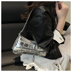 Silver metallic hobo bag with punk studs and buckle straps worn over the shoulder