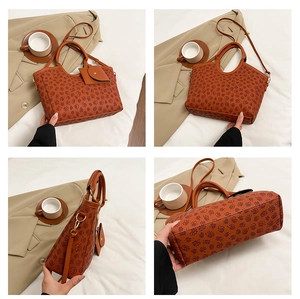 Detail view of brown tote bag with clover pattern including mini pouch and crossbody strap