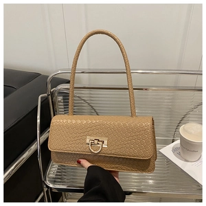 Detail of beige woven faux leather texture and gold metal buckle on a shoulder bag