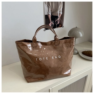 Detail of waterproof brown tote bag with TOTE BAG print on textured glossy PVC surface