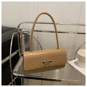 Detail of woven leather texture and golden metal twist lock on a beige shoulder bag
