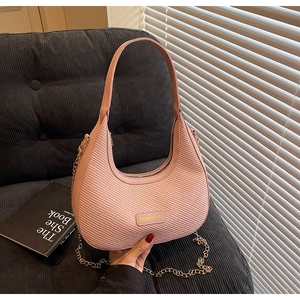 Detail of pink woven hobo bag with gold Miss Mini plaque and elegant chain strap