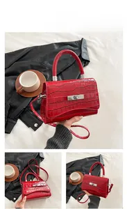 Detail of red crocodile texture handbag with silver metal buckle and top handle