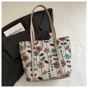 Detail of vintage floral tapestry tote bag with leather trim and woven flower patterns