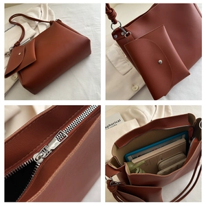 Detail of brown tote bag set with rope knot handle, silver zipper and large inner capacity
