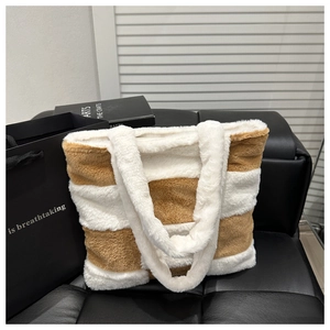 Detail of plush striped tote bag with cream and brown faux fur texture on a leather chair