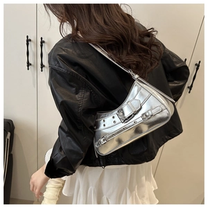 Close-up of silver Y2K shoulder bag featuring metallic finish and decorative eyelet straps