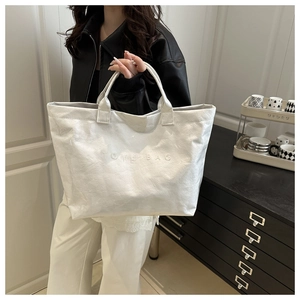 Macro shot of white waterproof tote bag featuring embossed TOTE BAG text and crinkled texture