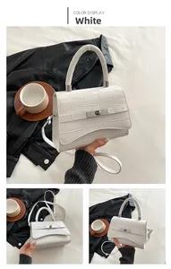 Close-up of white croc-embossed small square bag with silver twist lock and single handle